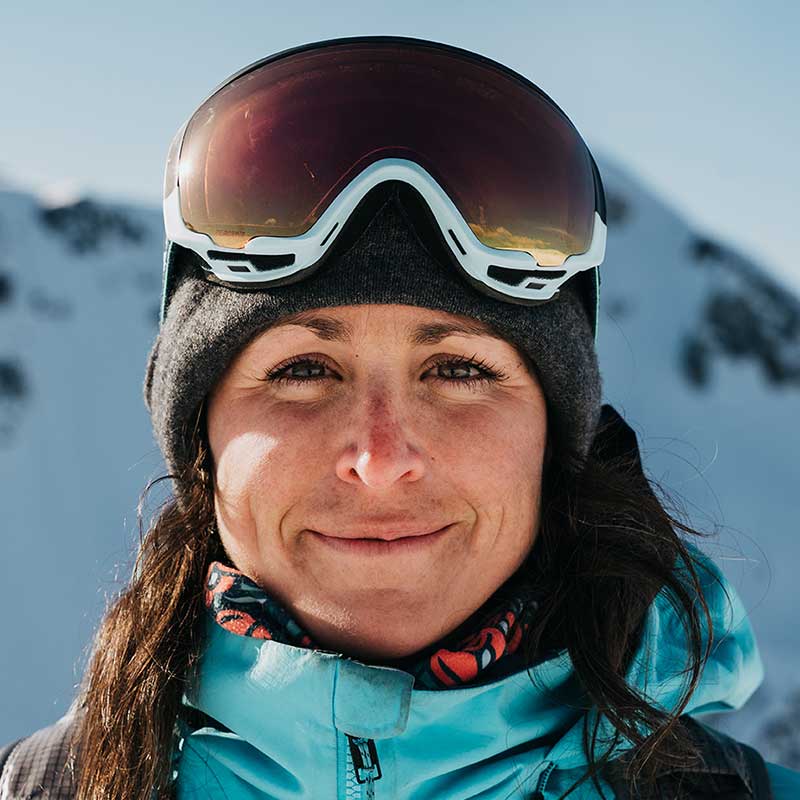 girl staring at camera with snowboard goggles on her head
