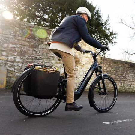 cyclist on an e-bike with a big bag pannier on the back
