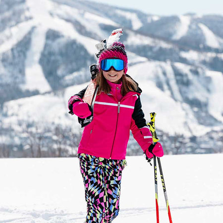 girl walking in the snow with her skis