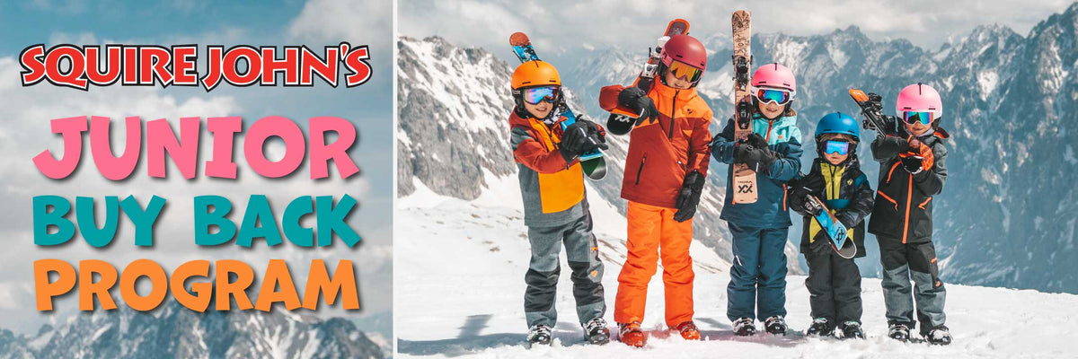 Kids standing on a mountain with their skis