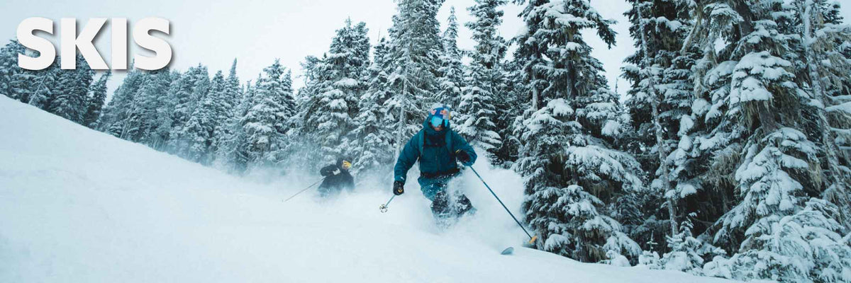 two skiers skiing through deep powder