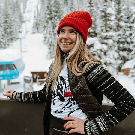 woman standing outside with a ski hill in the background